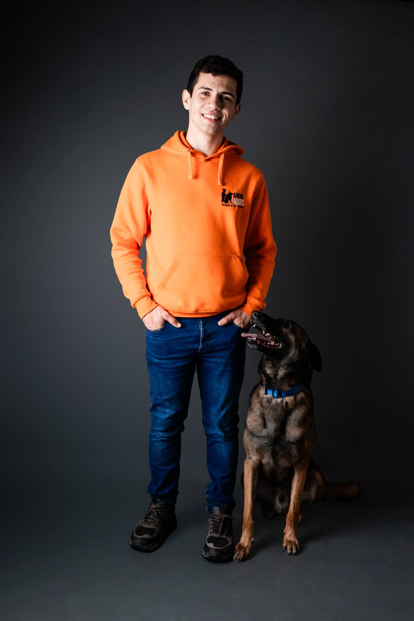 André Alves, treinador de cães certificado, ao lado de um pastor belga malinois